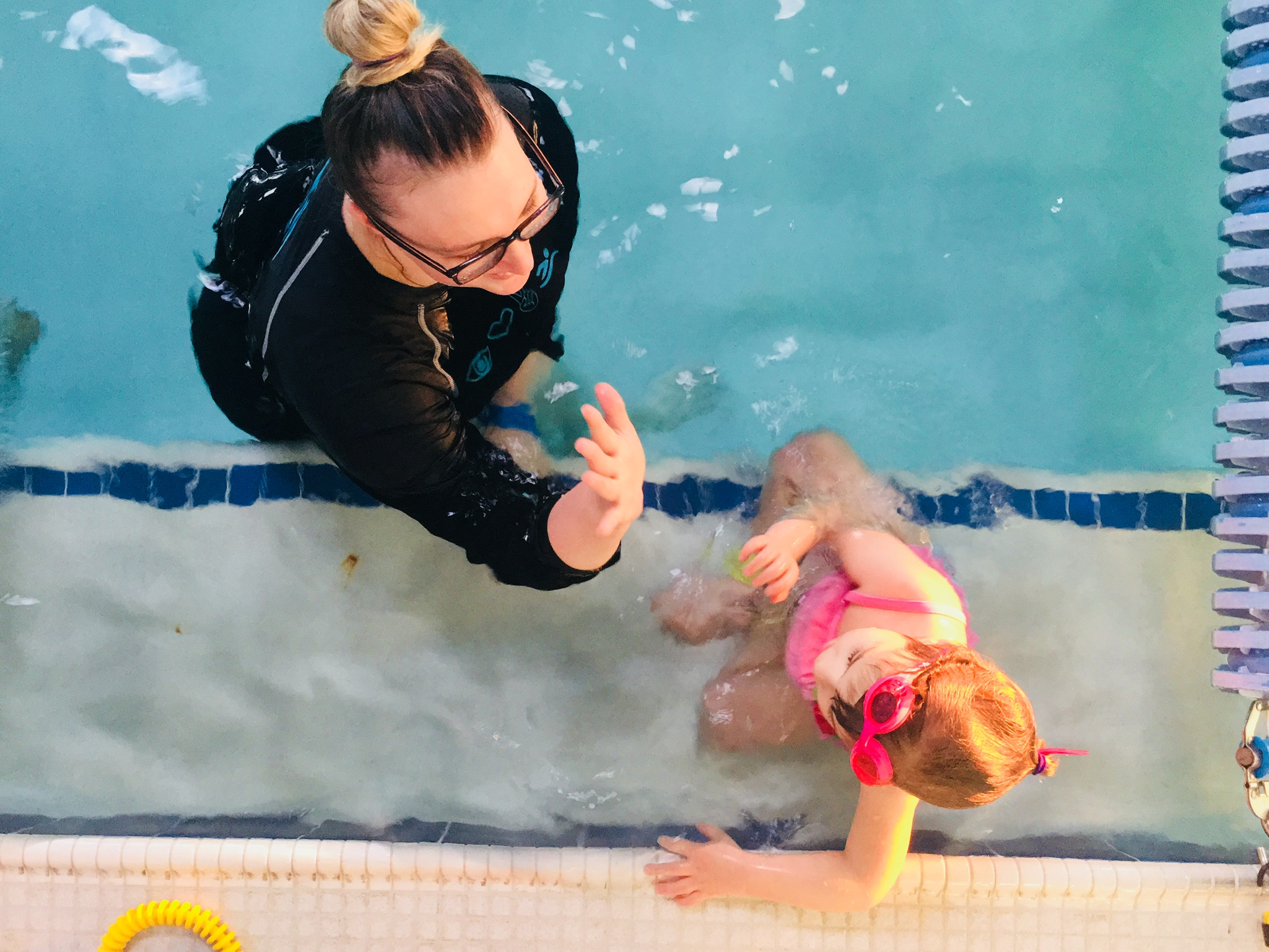 Loving coach gives high 5 for successful swimming