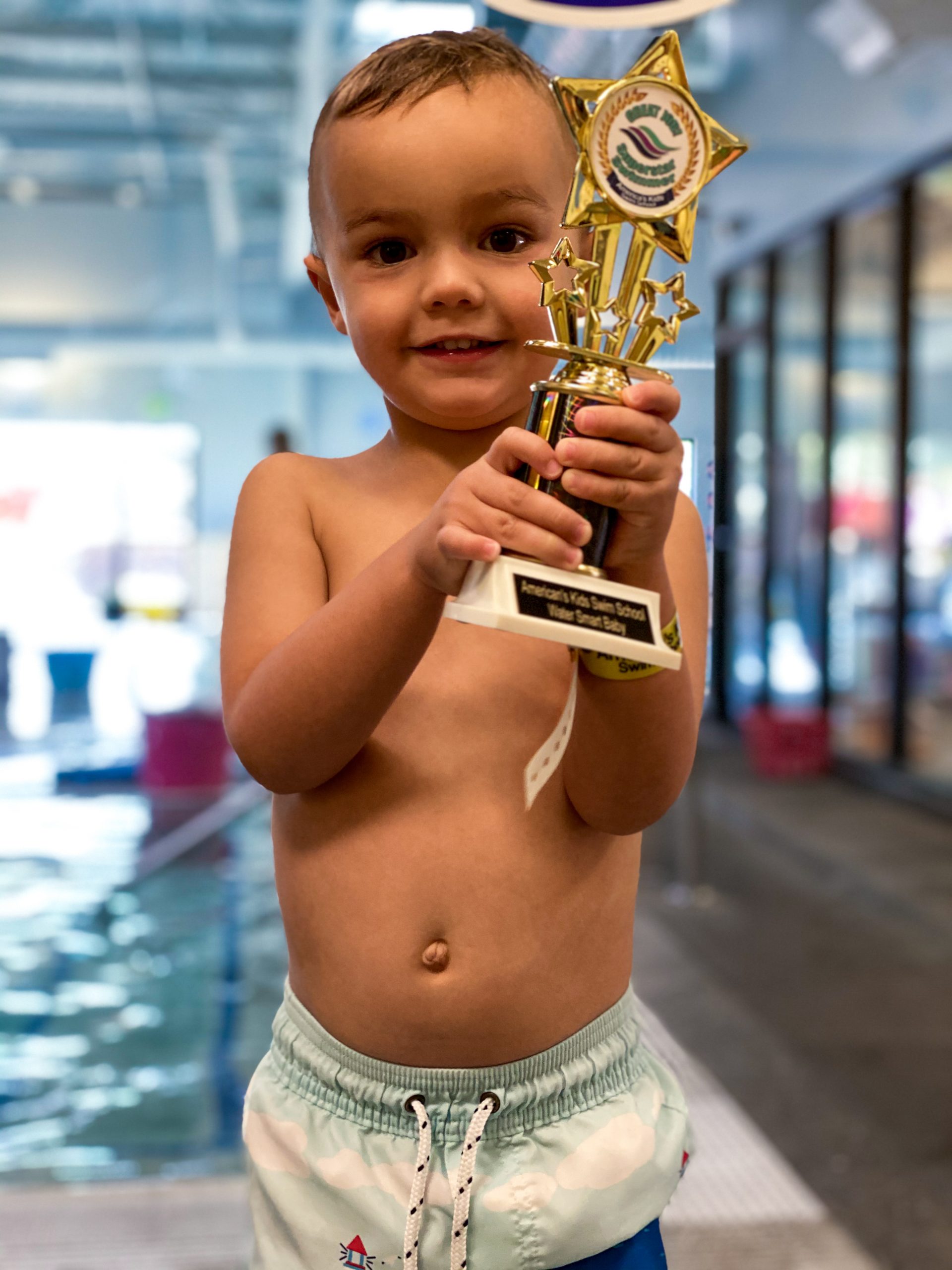 Toddler receives trophy for completing swim course