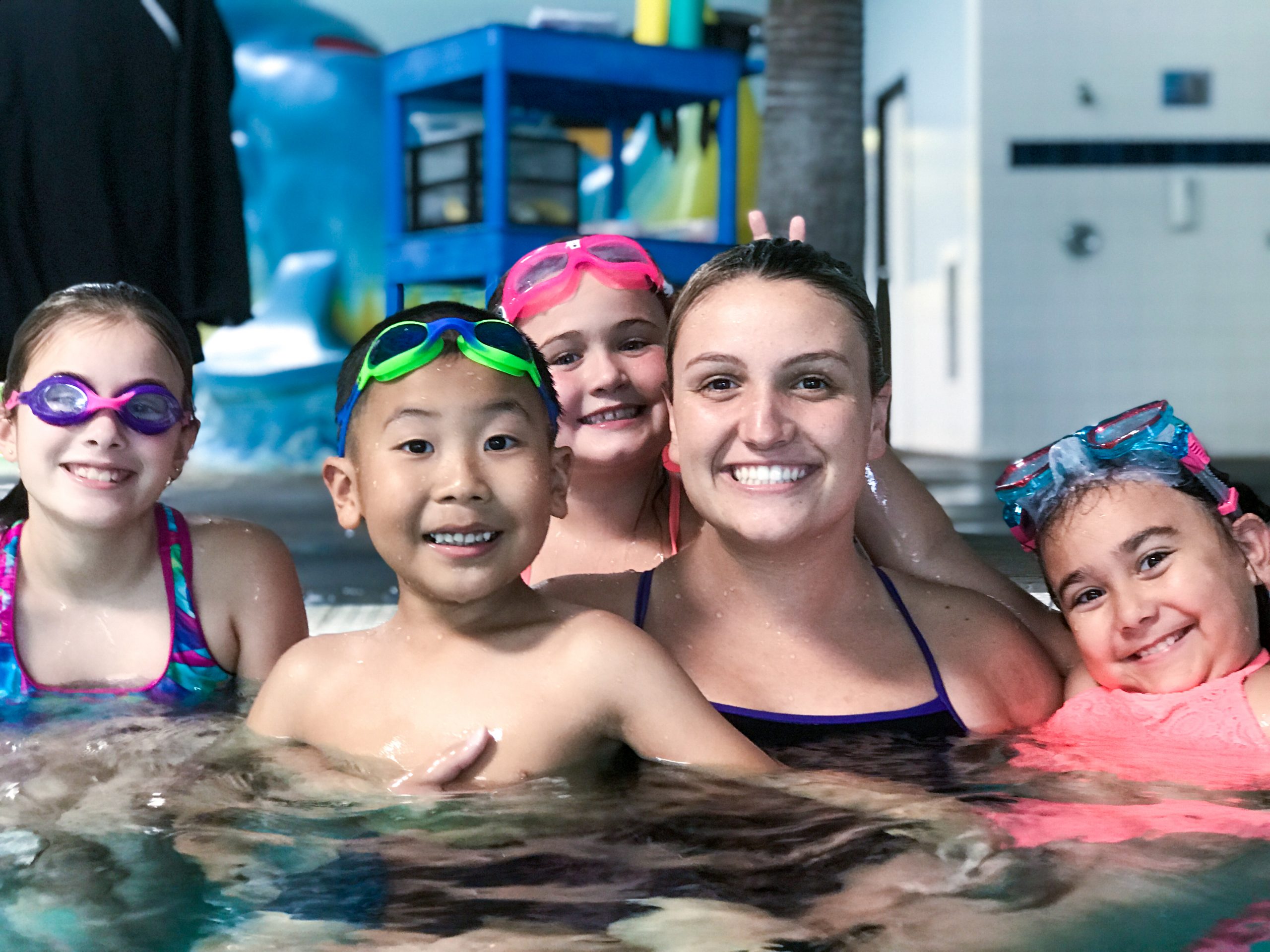 Students and Coach smiling during their fun swim class