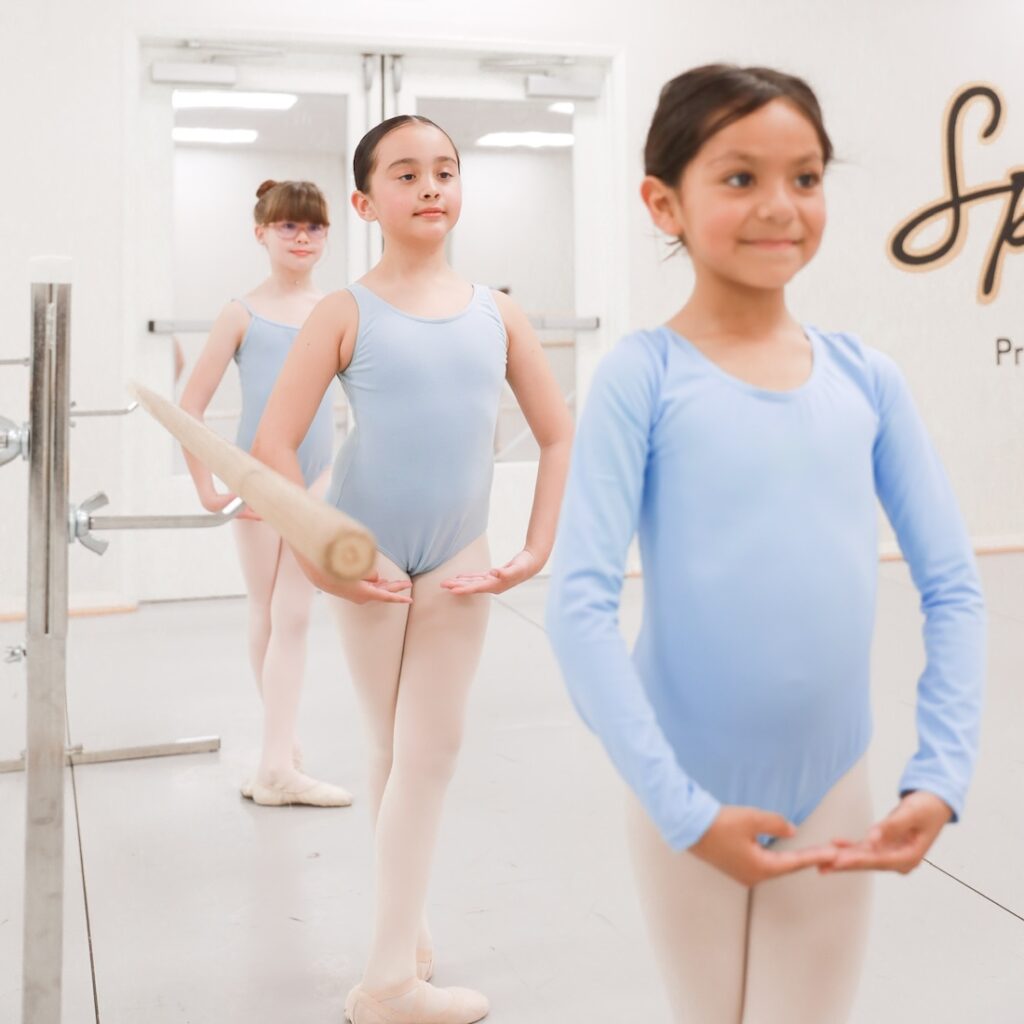 Three young ballerinas wearing blue