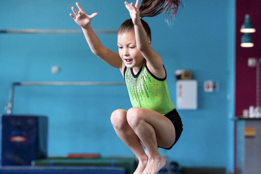 Young gymnast tuck jumping.