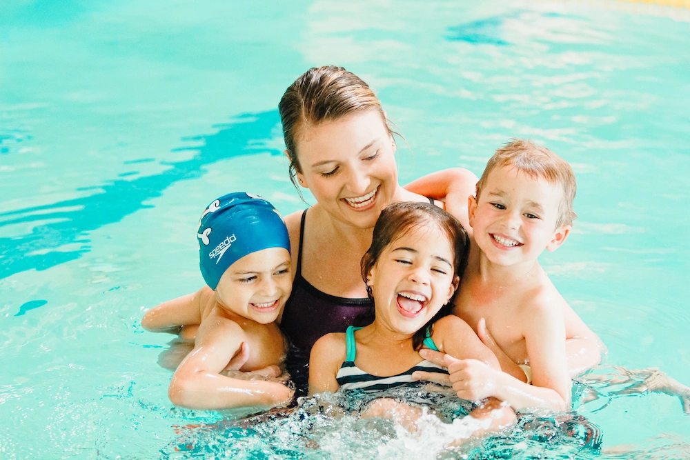 Mom swimming with her kids at an America's Kids In Motion swimming lesson.