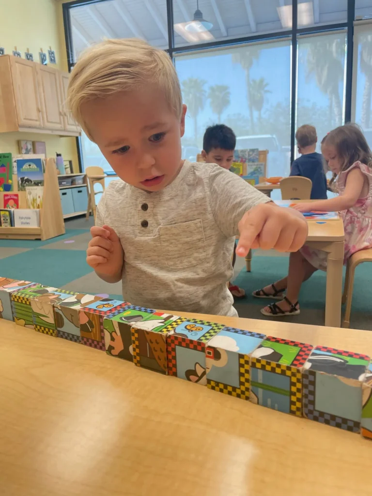 Preschool student organizing blocks.
